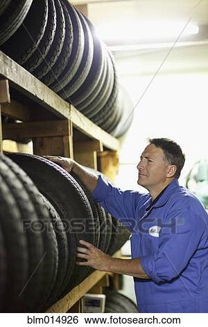 Stock Photograph - Caucasian worker in tire store. Fotosearch