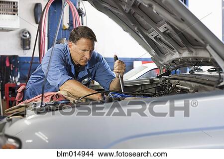 Caucasian worker working on automobile engine View Large Photo Image Picture - Caucasian worker working on automobile engine. Fotosearch