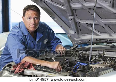 Caucasian worker working on automobile engine View Large Photo Image Stock Photo - Caucasian worker working on automobile engine. Fotosearch