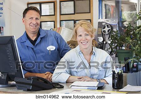 Caucasian workers standing at desk View Large Photo Image Stock Image - Caucasian workers standing at desk. Fotosearch
