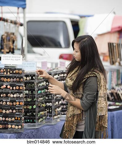 Chinese woman shopping for jewelry at flea market View Large Photo Image Stock Photograph - Chinese woman shopping for jewelry at flea market. Fotosearch