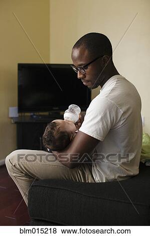 Stock Photo - Father feeding baby. Fotosearch