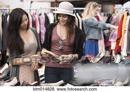 Stock Photo - Friends shopping at flea market. Fotosearch
