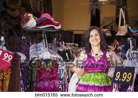 Stock Photography - Hispanic woman shopping for dress. Fotosearch