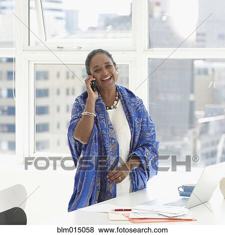 Indian businesswoman using cell phone at desk View Large Photo Image Stock Photo - Indian businesswoman using cell phone at desk. Fotosearch