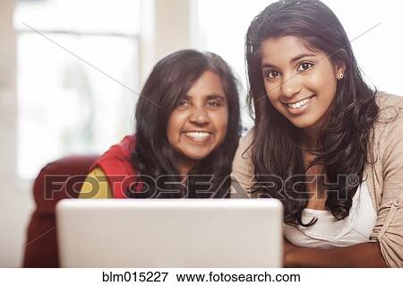 Stock Photo - Indian mother and daughter using laptop together. Fotosearch
