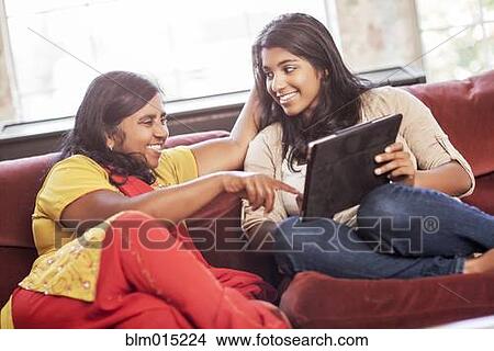 Picture - Indian mother and daughter using digital tablet. Fotosearch
