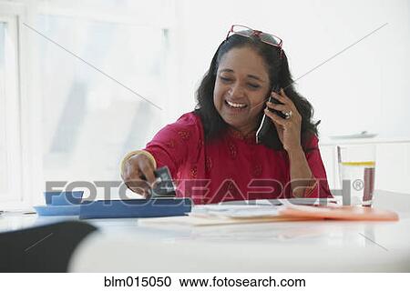 Stock Image - Indian woman shopping online with credit card. Fotosearch