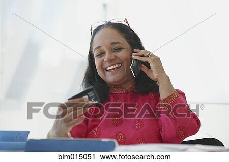 Stock Image - Indian woman shopping online with credit card. Fotosearch