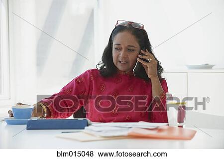 Indian woman working and talking on telephone View Large Photo Image Stock Photo - Indian woman working and talking on telephone. Fotosearch