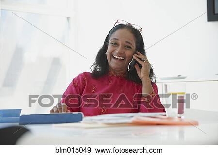 Stock Photo - Indian woman working and talking on telephone. Fotosearch