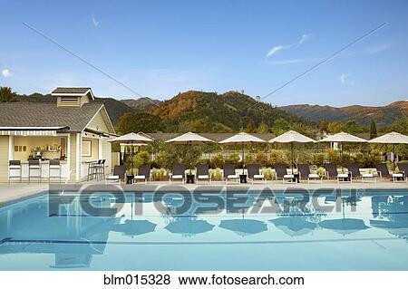 Stock Photo - Lounge chairs near swimming pool. Fotosearch
