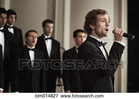 Man singing with choir on stage View Large Photo Image Stock Photo - Man singing with choir on stage. Fotosearch