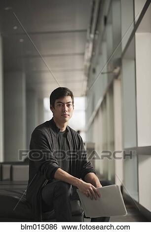 Stock Photograph - Mixed race businessman holding papers. Fotosearch