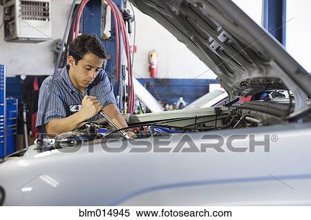 Mixed race worker working on automobile engine View Large Photo Image Stock Photography - Mixed race worker working on automobile engine. Fotosearch