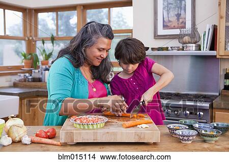 Picture - Mother and daughter cooking in kitchen. Fotosearch