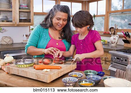 Stock Image - Mother and daughter cooking in kitchen. Fotosearch