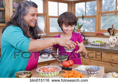 Mother and daughter cooking in kitchen View Large Photo Image Stock Photograph - Mother and daughter cooking in kitchen. Fotosearch