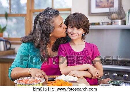 Stock Photography - Mother and daughter cooking in kitchen. Fotosearch