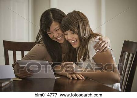 Stock Photo - Mother helping daughter with homework. Fotosearch