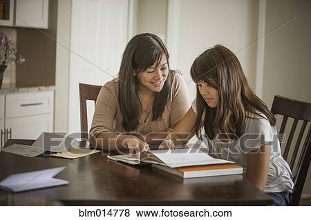 Stock Photo - Mother helping daughter with homework. Fotosearch