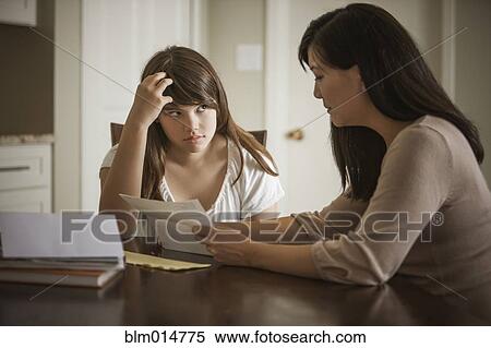 Stock Photography - Mother helping daughter with homework. Fotosearch