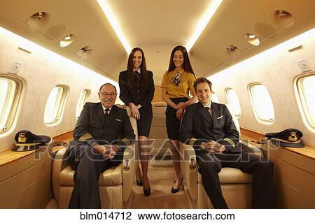 Stock Image - Pilots and fight staff in private jet. Fotosearch
