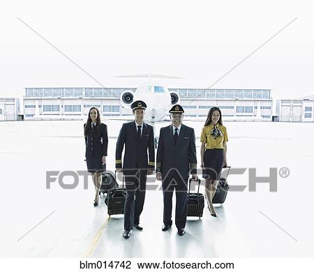Stock Image - Pilots and flight staff on tarmac. Fotosearch