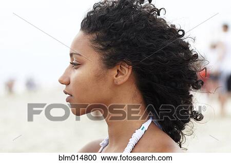 Stock Image - Serious mixed race woman on beach. Fotosearch
