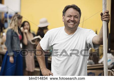 Picture - Smiling Caucasian man at flea market. Fotosearch