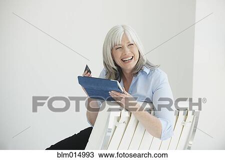 Stock Image - Smiling Caucasian woman shopping with credit card on digital tablet. Fotosearch