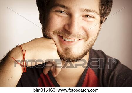 Stock Image - Smiling man with hand on chin. Fotosearch