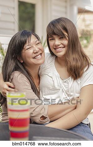 Smiling mother and daughter hugging View Large Photo Image Stock Photo - Smiling mother and daughter hugging. Fotosearch