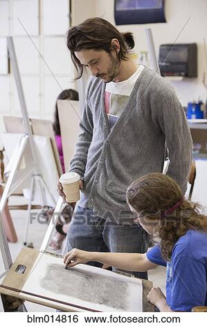 Teacher helping student in art class View Large Photo Image Stock Photograph - Teacher helping student in art class. Fotosearch