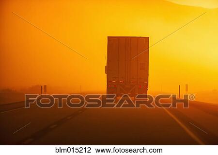 Truck driving down road in dust storm View Large Photo Image Stock Image - Truck driving down road in dust storm. Fotosearch