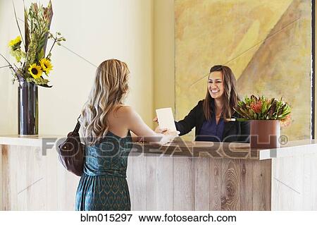 Woman checking in at hotel View Large Photo Image Stock Photo - Woman checking in at hotel. Fotosearch