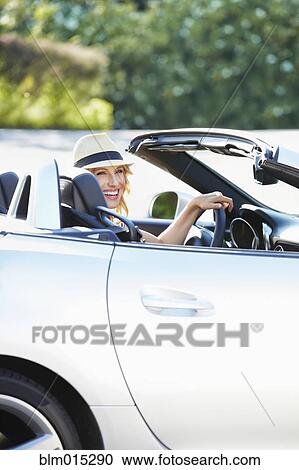 Stock Image - Woman driving convertible. Fotosearch