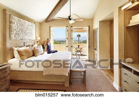 Stock Photo - Woman in elegant bedroom. Fotosearch