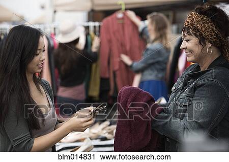 Woman paying for clothing at flea market View Large Photo Image Stock Image - Woman paying for clothing at flea market. Fotosearch