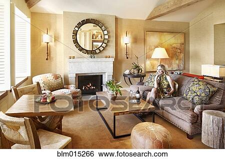Stock Photograph - Woman sitting in elegant living room. Fotosearch