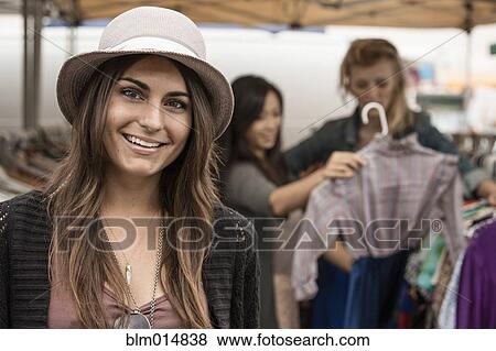 Stock Photo - Woman standing in flea market. Fotosearch