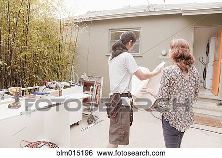 Stock Photograph - Woman talking with home contractor. Fotosearch