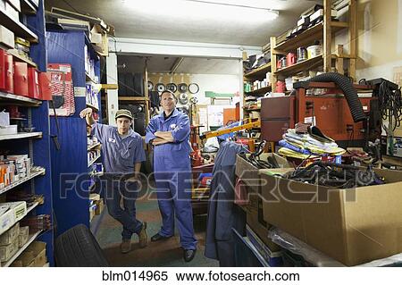Stock Photography - Workers standing in auto repair shop. Fotosearch