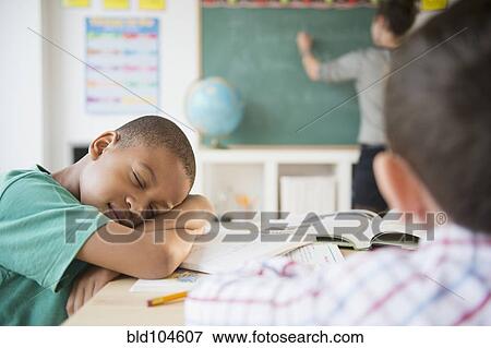 Stock Photo - African American boy sleeping in classroom. Fotosearch