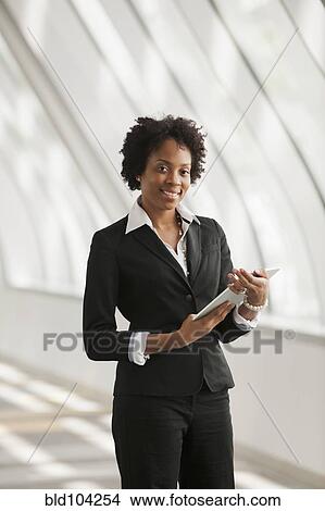 Picture - African American businesswoman holding digital tablet. Fotosearch