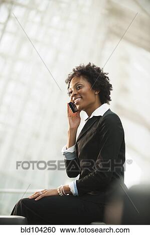 Stock Image - African American businesswoman talking on cell phone. Fotosearch