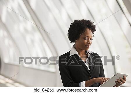 Stock Photography - African American businesswoman using digital tablet. Fotosearch