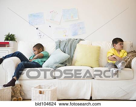 Picture - Angry boys sitting on sofa. Fotosearch