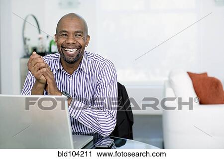Black businessman sitting with laptop View Large Photo Image Stock Image - Black businessman sitting with laptop. Fotosearch