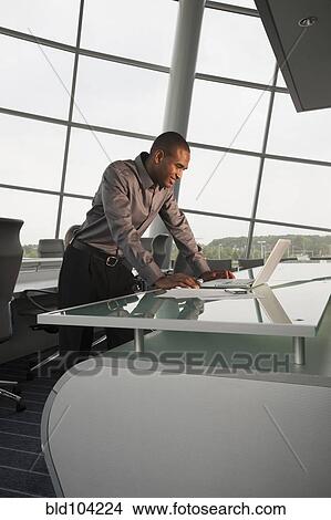 Picture - Black businessman using laptop in conference room. Fotosearch